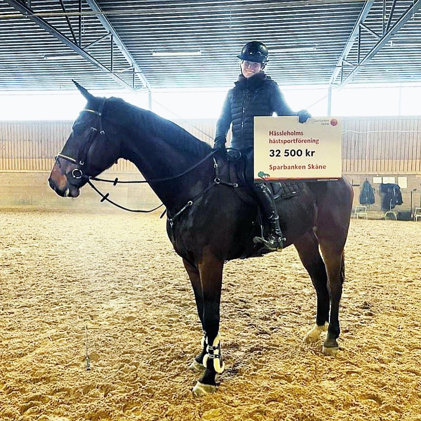 Bild på ryttare och häst med en skylt på bidraget från Sparbanken Skåne
